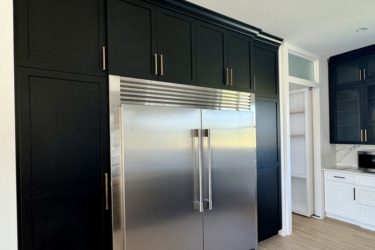 Custom black cabinetry with integrated refrigeration and oak-look flooring
