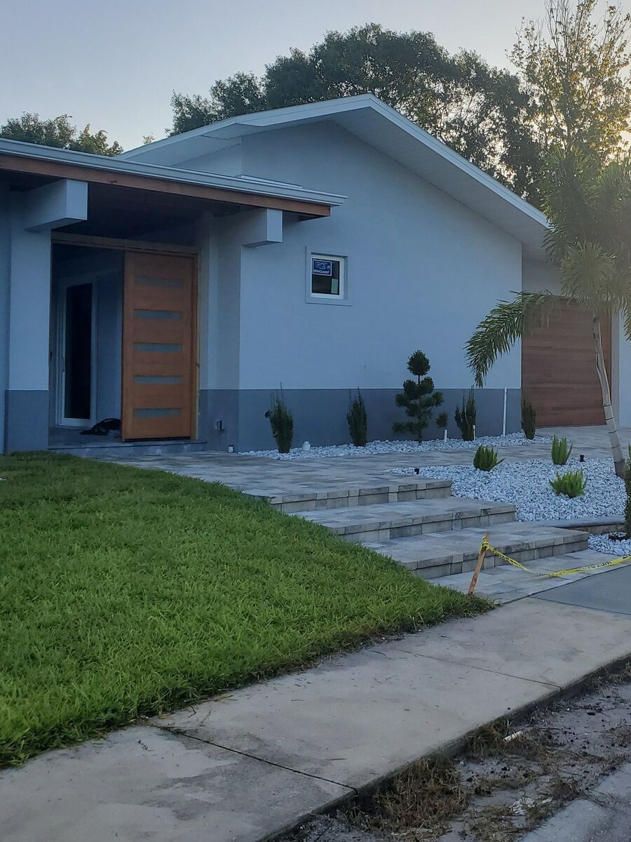 Contemporary home elevation with a wood entry door and white stone landscaping